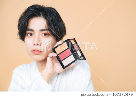 Young man with a makeup palette, genderless makeup, men's cosmetics, skin care, beauty Young man with a makeup palette, genderless makeup, men's cosmetics, skin care, beauty 107372479