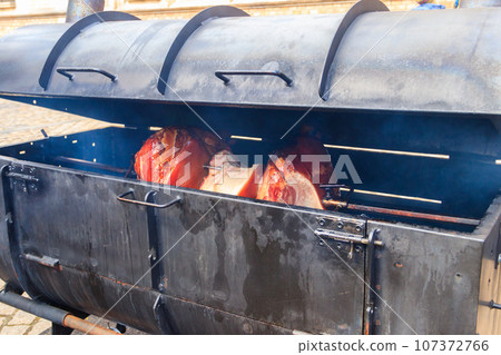 Czech smoked ham cooking on charcoal spit roaster in Prague streets, Czech Republic Czech smoked ham cooking on charcoal spit roaster in Prague streets, Czech Republic 107372766