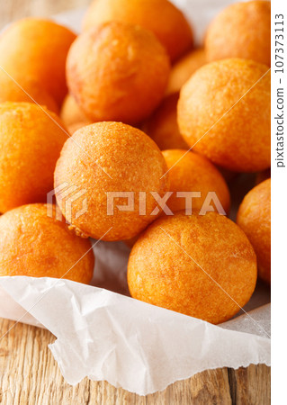 Kanom kai nok krata or fried sweet potato balls, are a common Thai street food closeup. Vertical Kanom kai nok krata or fried sweet potato balls, are a common Thai street food closeup. Vertical 107373113
