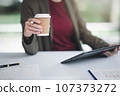 Concept of business office woman working,Businesswoman smile while working about her invesment plan with analyzing document and business investment graph data by using laptop on desk in workstation. 107373272