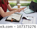 Concept of business office woman working,Businesswoman smile while working about her invesment plan with analyzing document and business investment graph data by using laptop on desk in workstation. 107373276