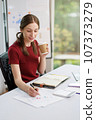 Concept of business office woman working,Businesswoman smile while working about her invesment plan with analyzing document and business investment graph data by using laptop on desk in workstation. 107373279