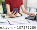 Concept of business office woman working,Businesswoman smile while working about her invesment plan with analyzing document and business investment graph data by using laptop on desk in workstation. 107373280