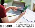 Concept of business office woman working,Businesswoman smile while working about her invesment plan with analyzing document and business investment graph data by using laptop on desk in workstation. 107373281