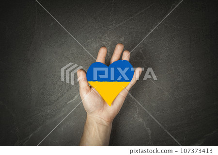 man hand hold blue yellow heart man hand hold blue yellow heart 107373413