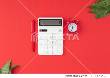 Pen with calculator, alarm clock on red background Pen with calculator, alarm clock on red background 107373422