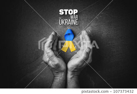 hand with yellow and blue ribbon on marble hand with yellow and blue ribbon on marble 107373432