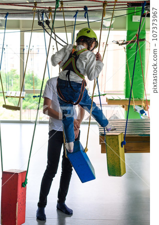 An older brother helps his sister pass a difficult section of the cableway . 107373967