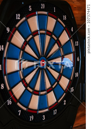 Close-up. Bright multicolored dartboard hangs on wall. Games and entertainment. Excitement , sport. 107374471