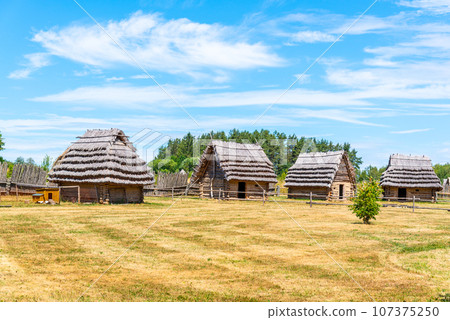 Small medieval village of shepherd huts with straw roof on sunny day. Small medieval village of shepherd huts with straw roof on sunny day. 107375250