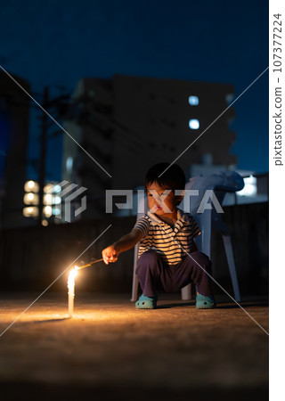 3 year old boy playing fireworks 3 year old boy playing fireworks 107377224