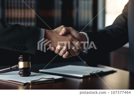 Cropped photo of a businessman shaking hands to seal a deal with his partner lawyers or attorneys discussing a contract agreement. 107377464