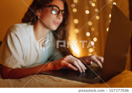 Working on laptop. Young woman studying sitting at home. Business, freelance, education concept. 107377696