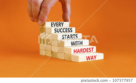Success symbol. Concept words Every success starts with hardest way on wooden block. Beautiful orange table orange background. Businessman hand. Business success and hardest way concept. Copy space. Success symbol. Concept words Every success starts with hardest way on wooden block. Beautiful orange table orange background. Businessman hand. Business success and hardest way concept. Copy space. 107377957