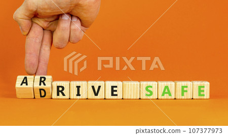 Drive and arrive safe symbol. Concept words Drive safe Arrive safe on wooden blocks. Beautiful orange table orange background. Businessman hand. Business drive and arrive safe concept. Copy space. 107377973
