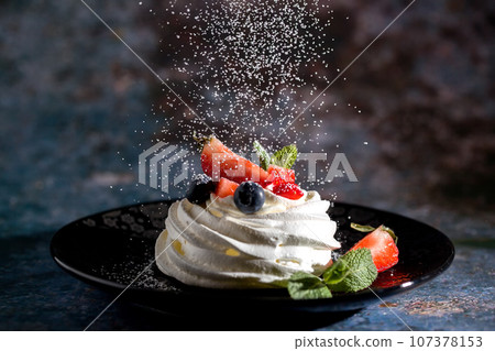 Powdered sugar decorates Pavlova's dessert Powdered sugar decorates Pavlova's dessert 107378153