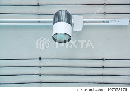 Close-up of white LED spotlight, on ceiling rail system, directional rotating light 107378176