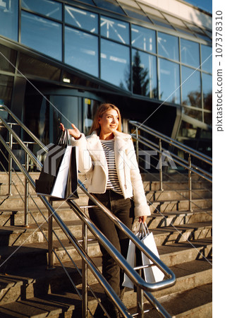 Young woman after shopping. Black friday. Consumerism, purchases, sale, lifestyle, tourism concept. Young woman after shopping. Black friday. Consumerism, purchases, sale, lifestyle, tourism concept. 107378310