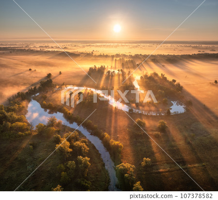 Aerial view of beautiful curving river in low clouds at sunrise Aerial view of beautiful curving river in low clouds at sunrise 107378582
