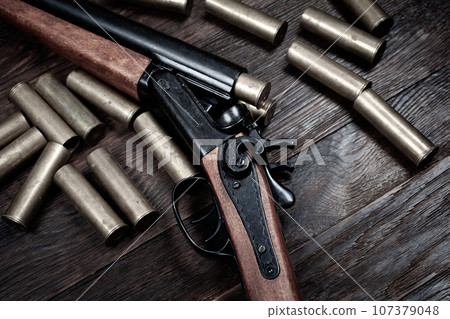 Antique 12-gauge break-action smooth-bored shotgun with yellow brass cases. Antique 12-gauge break-action smooth-bored shotgun with yellow brass cases. 107379048