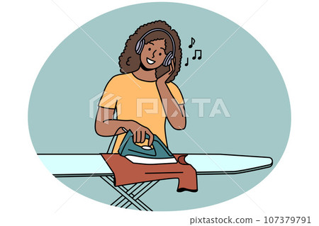 Smiling woman listen to music ironing clothes 107379791