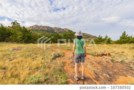 Woman hiking in the Elk Mountain Trail of the Wichita Mountains National Wildlife Refuge 107380502
