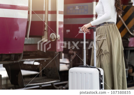 Woman traveler tourist walking with luggage at train station. Active and travel lifestyle concept Woman traveler tourist walking with luggage at train station. Active and travel lifestyle concept 107380835