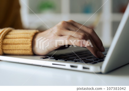 Closeup shot of hands using laptop and typing on keyboard, searching information Closeup shot of hands using laptop and typing on keyboard, searching information 107381042
