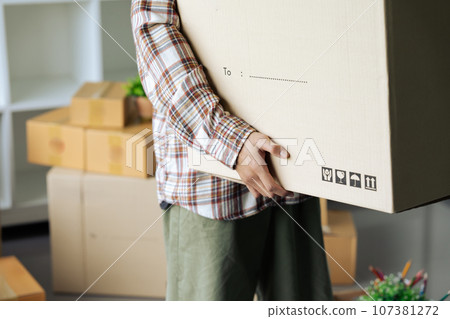 Close up of hand a man carrying box for moving into new apartment. relocation move home concept Close up of hand a man carrying box for moving into new apartment. relocation move home concept 107381272