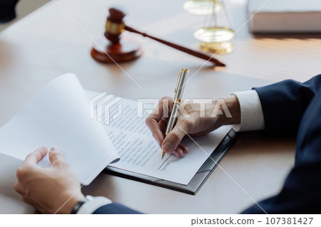 Lawyers or judges sign documents in accordance with legal and fair terms of agreement Lawyers or judges sign documents in accordance with legal and fair terms of agreement 107381427