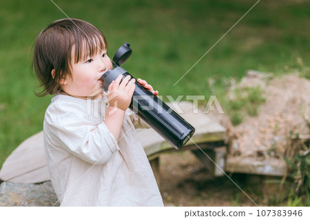 Young girl, toddler, child drinking water from a water bottle Young girl, toddler, child drinking water from a water bottle 107383946