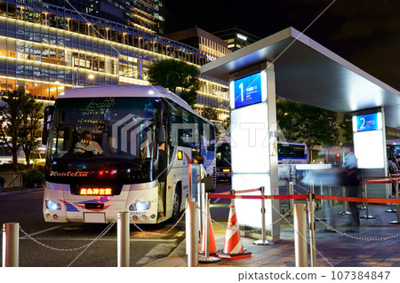 Kanto Railway bus bound for Kashima-Jingu Station stopping at the express bus terminal at the Yaesu Exit of JR Tokyo Station (night view, close-up) 107384847