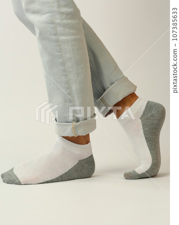 white gray sock with copy space on human feet closeup photo on white background 107385633