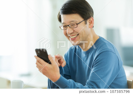 Senior man calling on smartphone 107385796