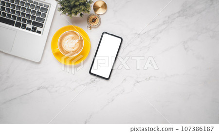 Office desk workplace with blank smartphone, laptop and cup of coffee, Top view flat lay with copy space. Office desk workplace with blank smartphone, laptop and cup of coffee, Top view flat lay with copy space. 107386187