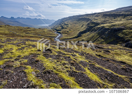 Berufjardara River and Fossarfell mountain in eastern Iceland on sunny morning. Berufjardara River and Fossarfell mountain in eastern Iceland on sunny morning. 107386867