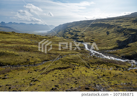 Berufjardara River and Fossarfell mountain in eastern Iceland on sunny morning. Berufjardara River and Fossarfell mountain in eastern Iceland on sunny morning. 107386871