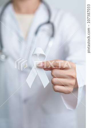 November Lung Cancer Awareness month. Doctor with White ribbon in hospital. Healthcare and World Cancer day concept 107387033