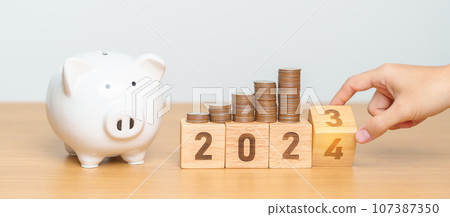 Happy New Year with piggy bank and flipping 2023 change to 2024 block. Resolution, Goals, Plan, Action, Money Saving, Retirement fund, Pension, Investment and Financial concept 107387350