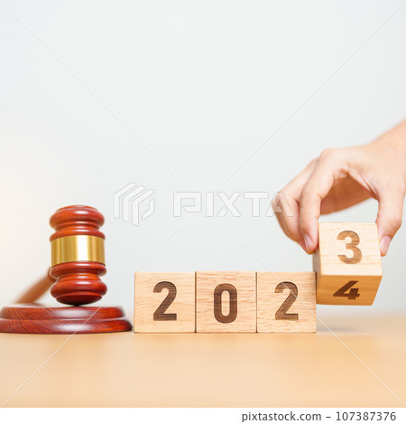 2023 chcnge to 2024 year block with judge gavel on table. Law, lawyer, judgment, justice auction and bidding concept 107387376