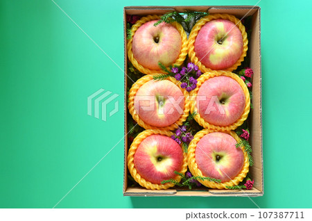 beautiful pink apple in the box on green background 107387711