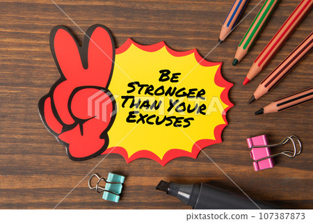 Be Stronger Than Your Excuses. Sticky note with text on wooden texture table Be Stronger Than Your Excuses. Sticky note with text on wooden texture table 107387873