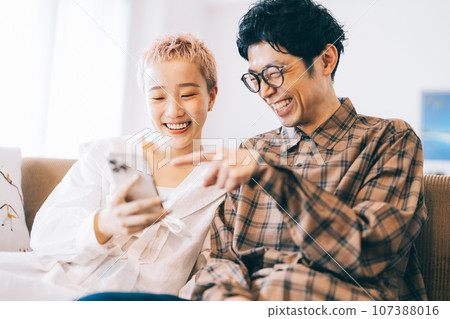 Couple looking at a smartphone together 107388016