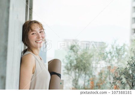 Yoga - woman with yoga mat on the roof of a building in the city 107388181