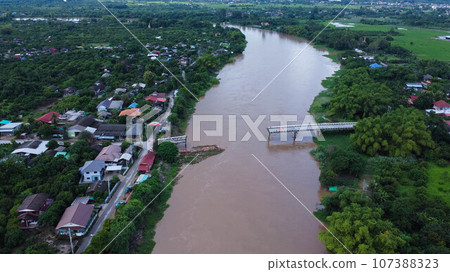 Aerial view of a damaged road bridge over a river after floodwaters washed away the asphalt. Broken bridge after flash floods in the rainy season. Aerial view of a damaged road bridge over a river after floodwaters washed away the asphalt. Broken bridge after flash floods in the rainy season. 107388323