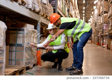 Managers men workers doing stocktaking of product management on shelves in warehouse Managers men workers doing stocktaking of product management on shelves in warehouse 107388739