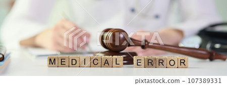 Gavel lies on wooden blocks put in words Medical Error 107389331