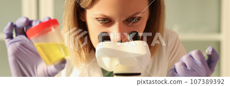 Laboratory worker does urine test using modern microscope Laboratory worker does urine test using modern microscope 107389392