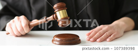 Female judge knocks with gavel near packs of dollars Female judge knocks with gavel near packs of dollars 107389398