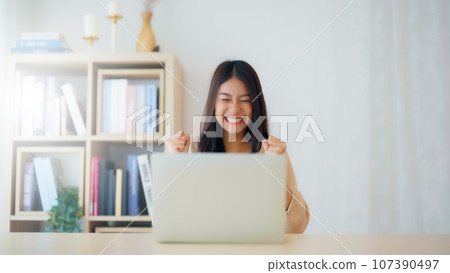 Funny euphoric young asian woman celebrating winning 107390497